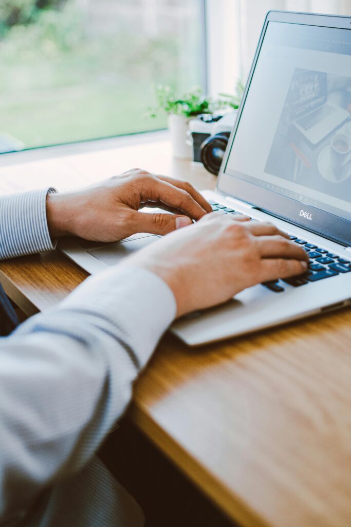 Jak Samodzielnie Wypozycjonować Stronę Internetową w Google A man working on a laptop in a modern office setting.